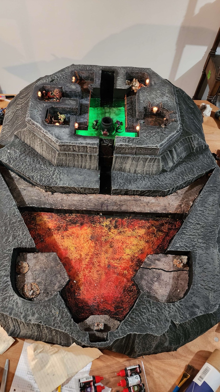Overhead view of the whole map, showing the tiered octagonal shrine platform above and the lava basin below, with torch-lit alcoves cut into both tiers.